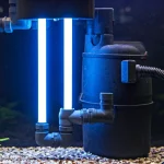 Detailní pohled na svítící UV lampu zapojenou k akvarijnímu filtru